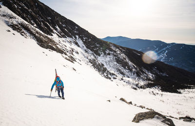 Man skiing on snowcapped mountain against sky