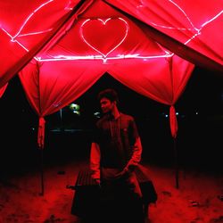 Full length of woman standing with red umbrella