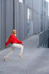 Cheerful african american woman with long blonde hair wearing sportswear and wearing headphones