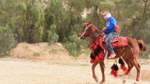 Full length of man riding horse