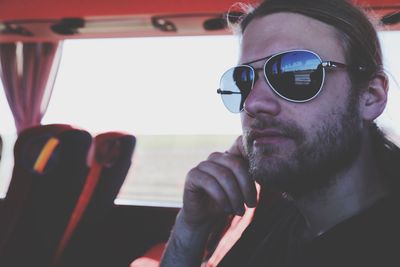 Mid adult man wearing sunglasses traveling in bus