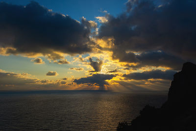 A thundercloud in the orange-yellow light of sunset. dramatic stormy sky. huge cumulus clouds 