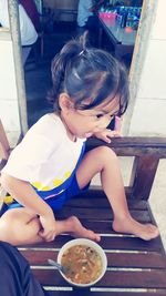 Cute girl sitting on table at restaurant