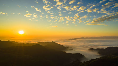 Scenic view of silhouette mountains against orange sky