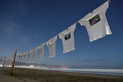 Low angle view of flag on beach against clear sky