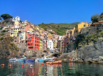 Scenic view of sea by town against clear blue sky