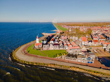 High angle view of buildings by sea against clear sky