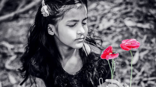 Close-up of woman holding red flowering plants