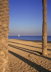 Scenic view of beach against clear blue sky