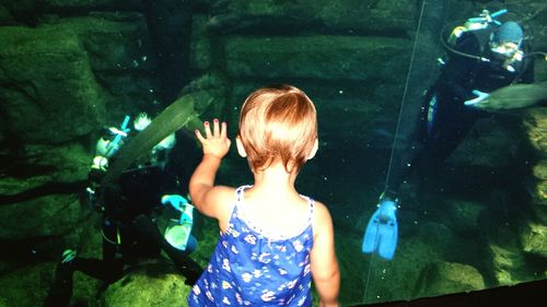 Rear view of boy standing in water