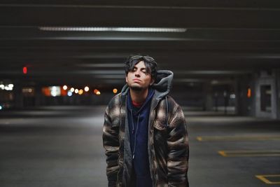 Portrait of young man standing in basement