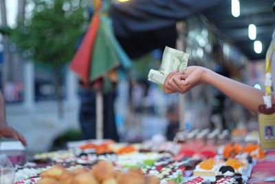 Close-up of hand holding paper currency at market stall