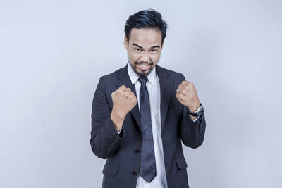 Portrait of smiling man standing against white background