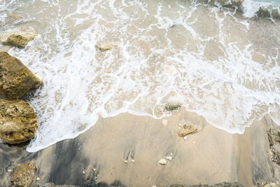 High angle view of sea waves splashing on rocks