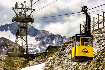 Low angle view of overhead cable car against sky