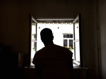 Rear view of silhouette man standing at home