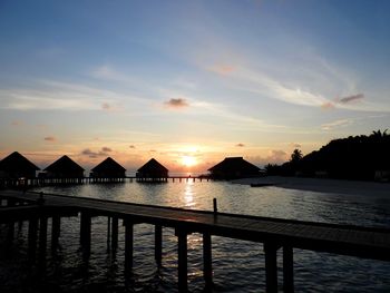 Pier over sea against sky during sunset