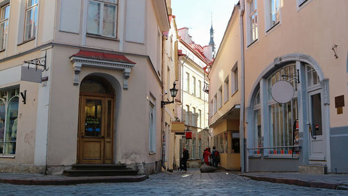 People on street amidst buildings in city