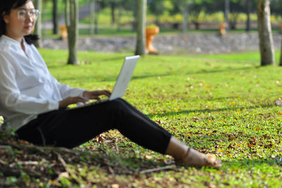 Side view of man using mobile phone in field