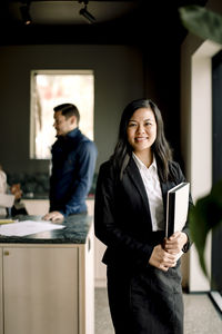 Portrait of smiling real estate agent standing in new house