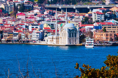 Sailboats in sea against buildings in city