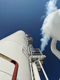 Low angle view of smoke emitting from factory against sky