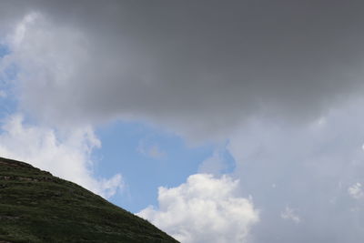 Low angle view of clouds over mountain