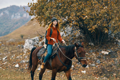 Full length of young woman riding horse