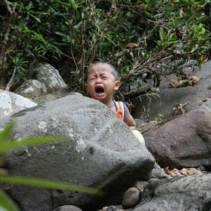 Portrait of boy smiling on rock