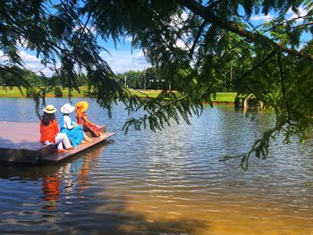 People sitting on boat in lake