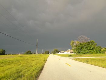 Road amidst field against sky
