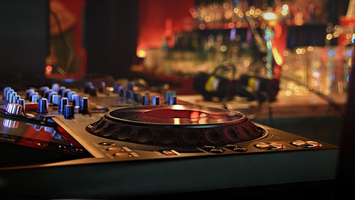 Close-up of illuminated lighting dj equipment on table at night