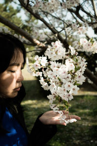 Close-up of woman holding white flowering plants