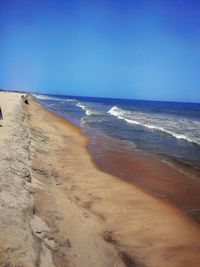 Scenic view of beach against clear blue sky