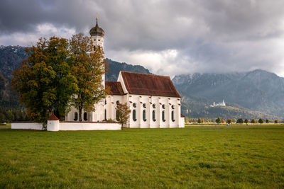 Traditional building by trees against sky