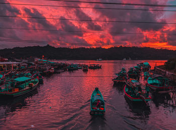 Boats in sea against sky during sunset
