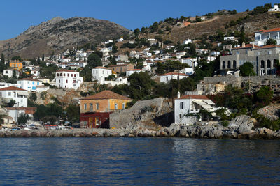 Houses by sea against sky in town