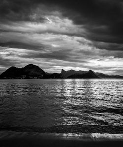 Scenic view of sea and mountains against sky