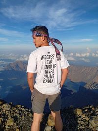 Man standing on rock against mountains