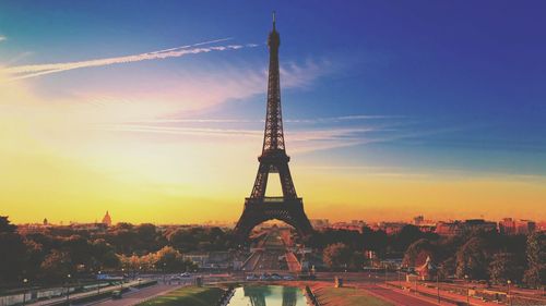 Eiffel tower in city against sky during sunset