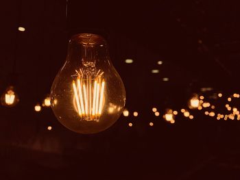 Close-up of illuminated light bulb against black background