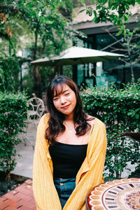 Portrait of a smiling young woman sitting outdoors