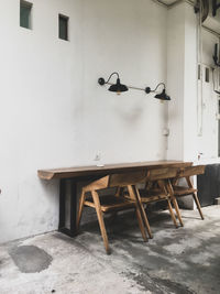 Empty chairs and table against wall in building