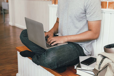 Low section of man using laptop