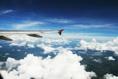 Airplane flying over clouds against blue sky