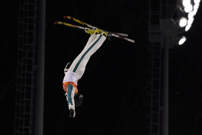 Full length of man with arms outstretched against black background