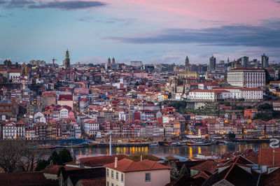 High angle view of buildings and river against cloudy sky at sunset