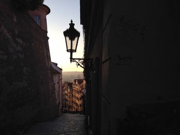 Low angle view of street lamp mounted on wall by walkway