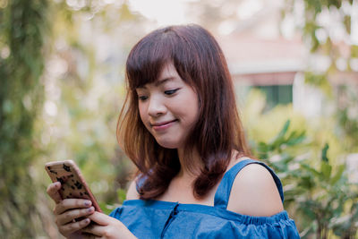 Portrait of young woman using mobile phone