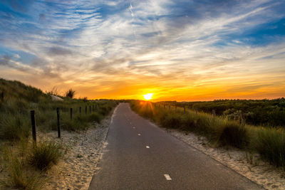 Road amidst landscape against sky during sunset